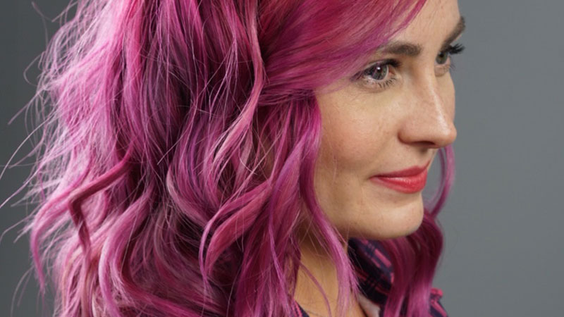 Molly Burke shows her profile to the camera with an ombre hair style using 3 shades of Magenta